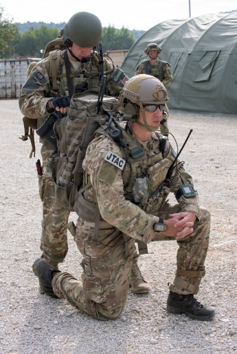 A Slovenian Soldier assist U.S. Air Force Staff Sgt. Eric Hansen, 2d Air Support Operations Squadron Vilseck, Germany, prepping his radios prior to making movement into the Immediate Resolve 15 training area. Immediate Response 15 is a multinational, brigade-level exercise utilizing computer-assisted simulations and field training exercises in Croatia and Slovenia. The exercises and simulations are built upon a scenario designed to enhance regional stability, strengthen partner capacity and improve interoperability between partner nations. The exercise will run Sept. 9-22, 2015, and will include more than 1,400 soldiers from Albania, Bosnia-Herzegovina, Croatia, Kosovo, Macedonia, Montenegro, Slovenia, the U.S. and the United Kingdom. Immediate Response 15 supports the goal of a “Strong Europe” in that partner nations are trained and ready to combine forces to ensure unified security across allied nations. Immediate Response is a preplanned exercise that has occurred annually for the past five years. Photo by: U.S. Army Photo (Mr. Tony Sweeney)